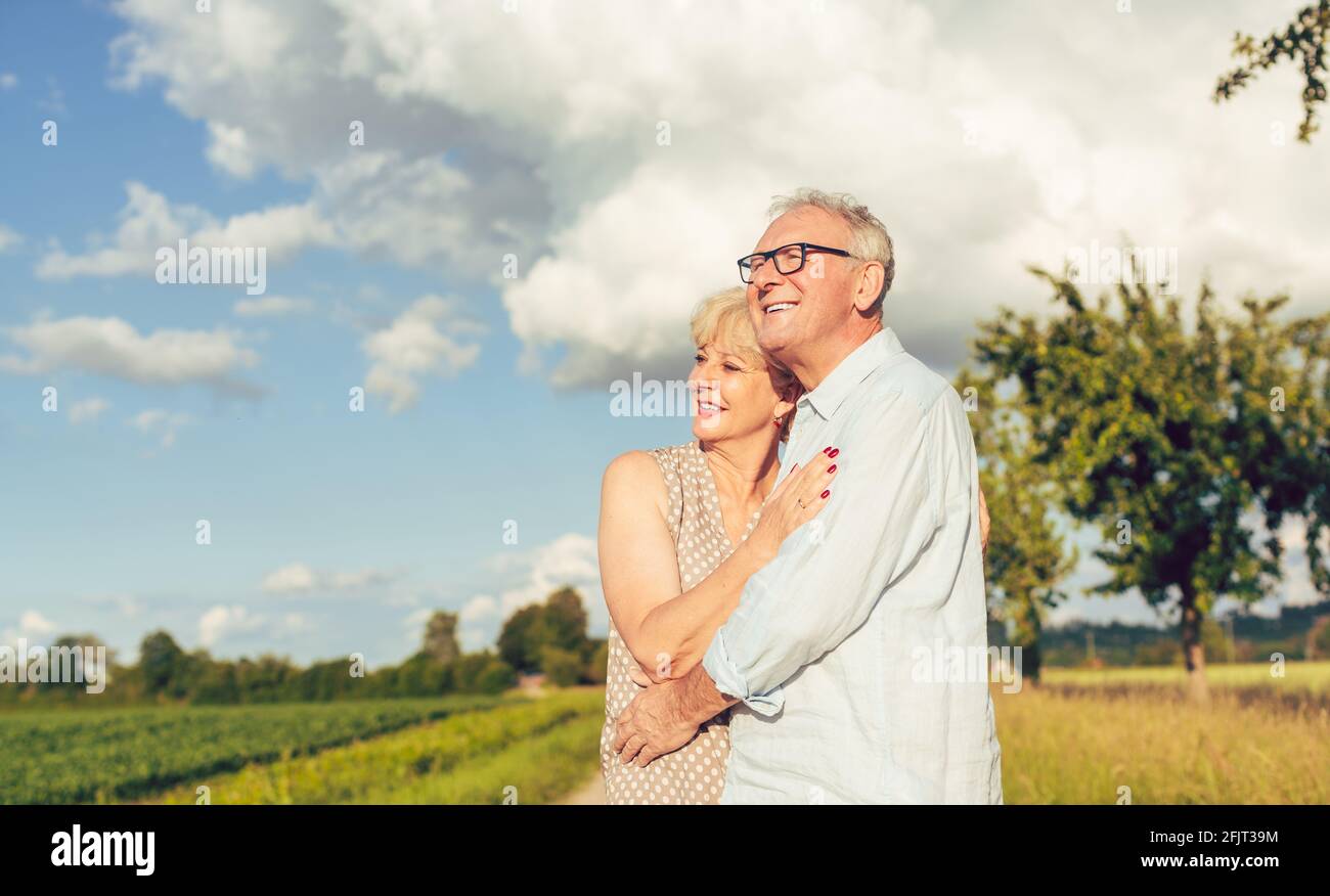 Senior couple in summer landscape looking into the future together Stock Photo