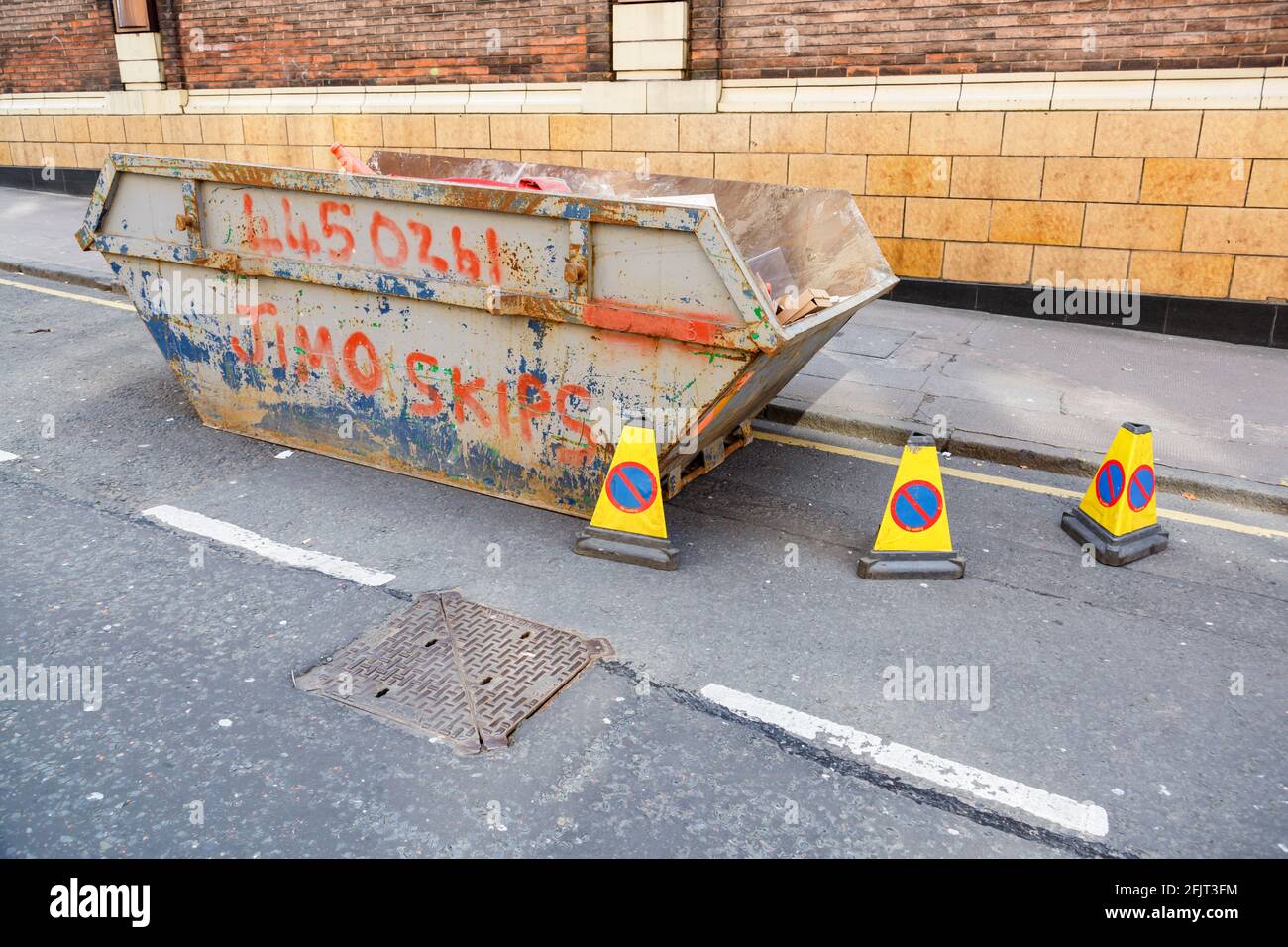 Builder's skip on a city road, Glasgow, Scotland, UK Stock Photo Alamy