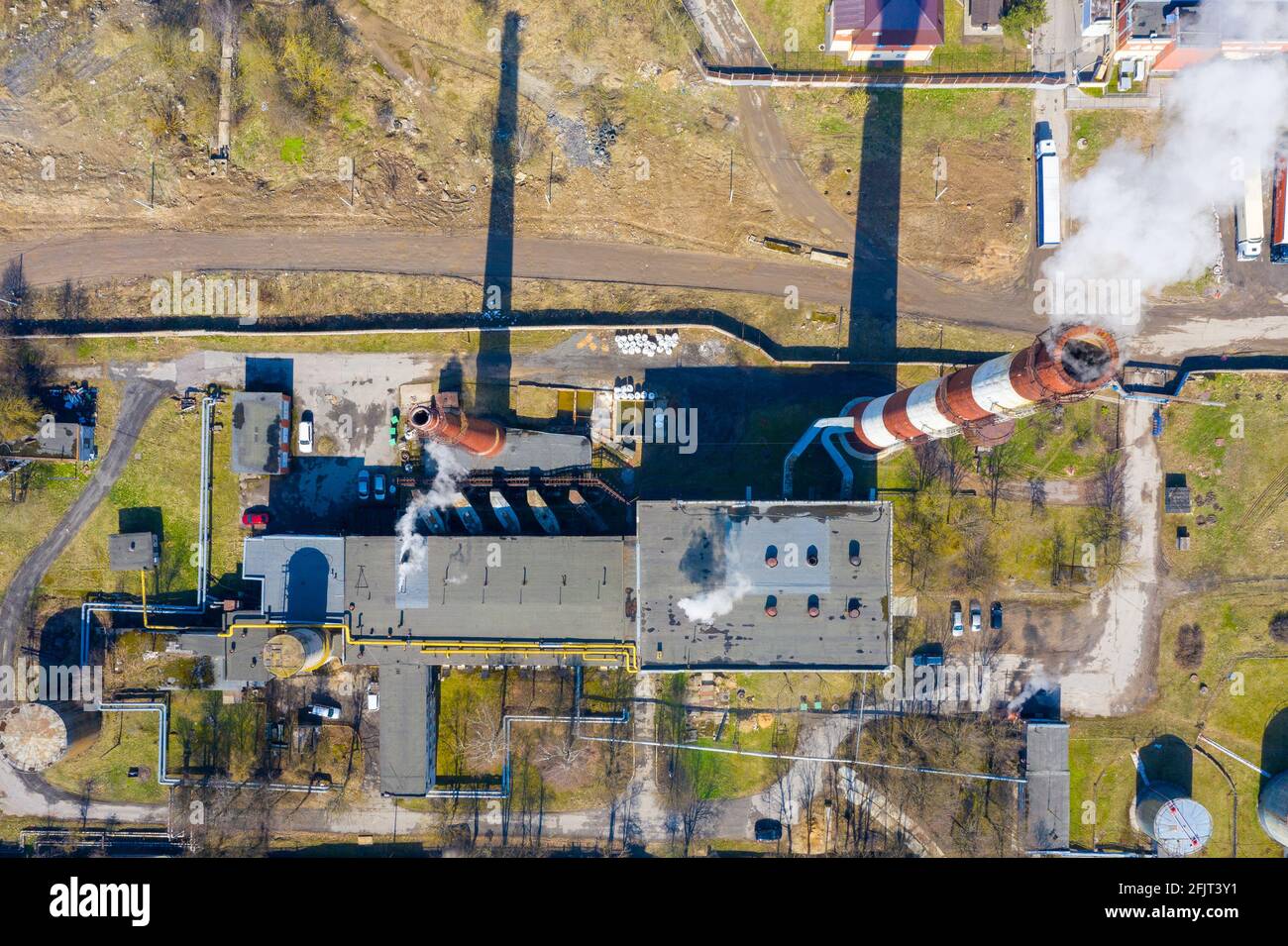 Aerial top view of an industrial building with smoke rising from the ...
