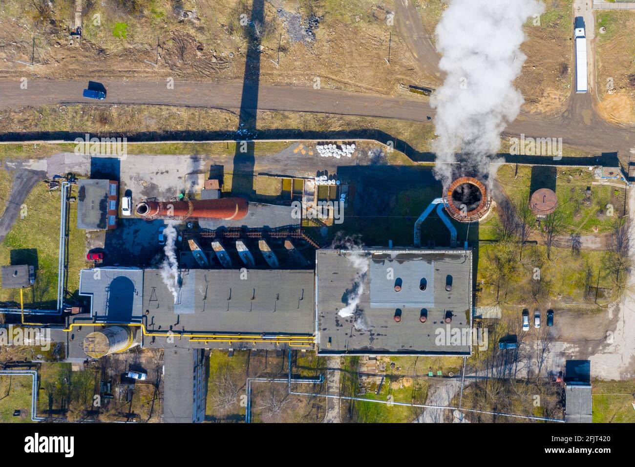 Aerial top view of an industrial building with smoke rising from the ...