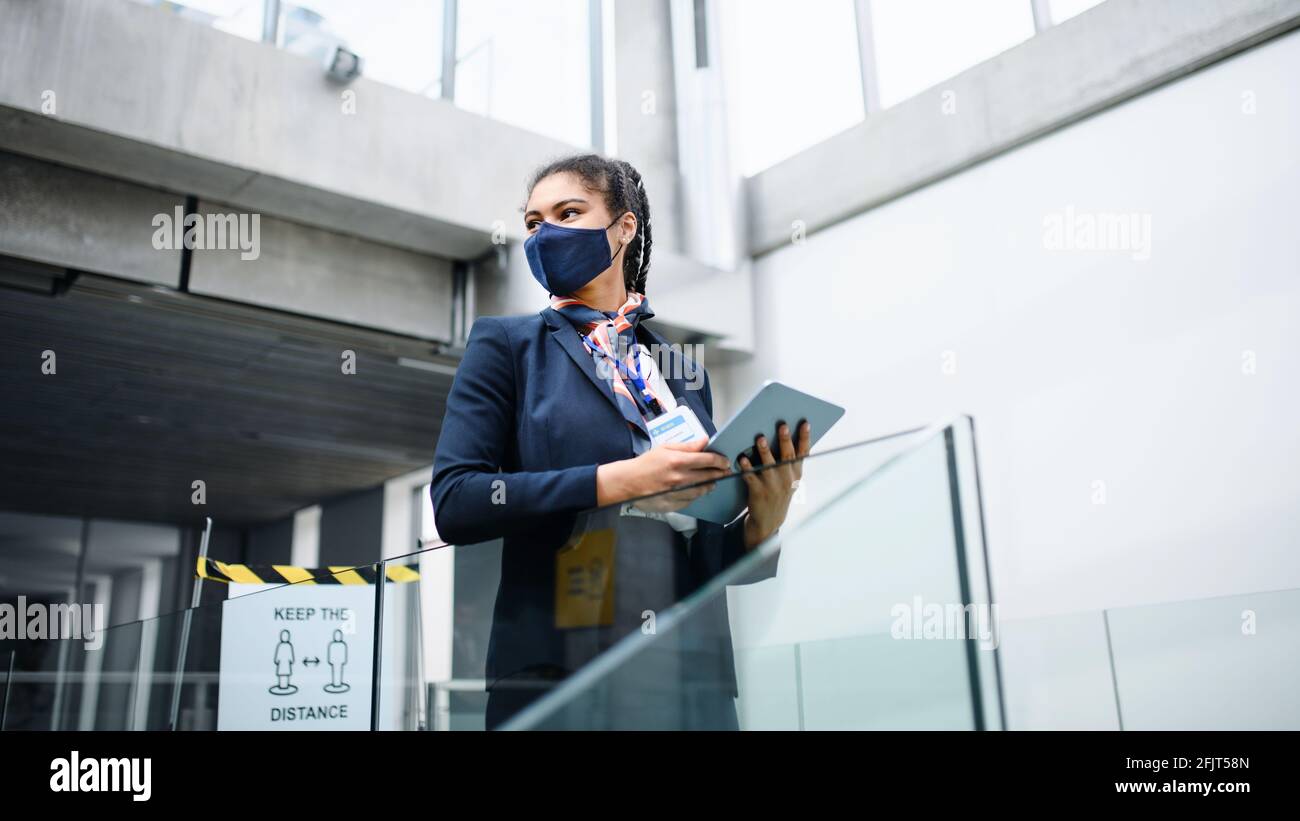 Young air hostess in airport lounge, coronavirus, travel and new normal. Stock Photo