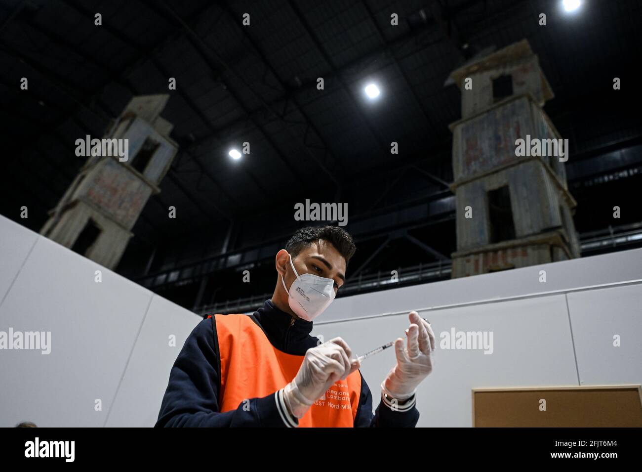 Milan, Italy. 26th April, 2021. A man prepares a syringe with Astrazeneca vaccine at the mass covid-19 vaccination hub coordinated by ASST Nord Milano opening today at “Pirelli HangarBicocca” where the monumental site-specific art installation ‘The Seven Heavenly Palaces 2004-2015' by artist Anselm Kiefer is on display. Credit: Piero Cruciatti/Alamy Live News Stock Photo