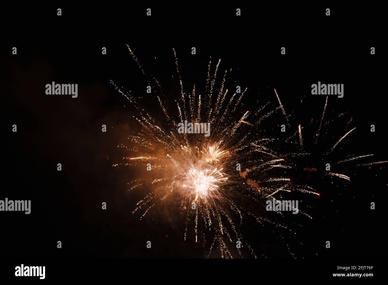 Colored fireworks explode in the night sky Stock Photo