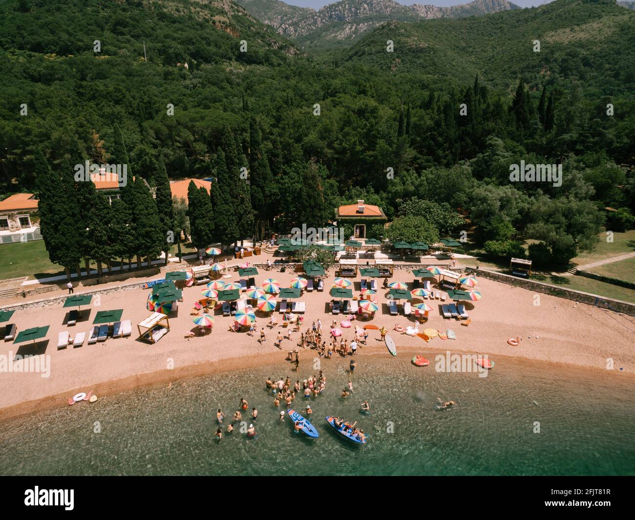 Top view of the royal beach in Przno. Colored sun umbrellas stand on the sand, people swim in the sea and sail in boats Stock Photo