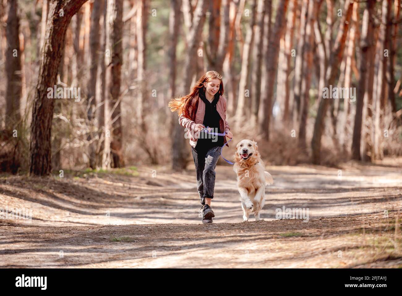 Girl with golden retriever dog in the wood Stock Photo - Alamy