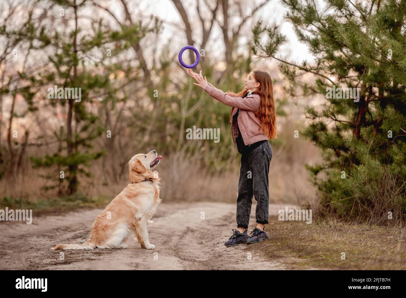 Girl with golden retriever dog in the wood Stock Photo - Alamy