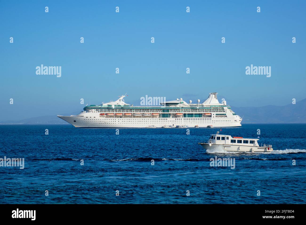 Boat and cruise liner is Aegean sea. Chora, Mykonos island, Greece Stock Photo