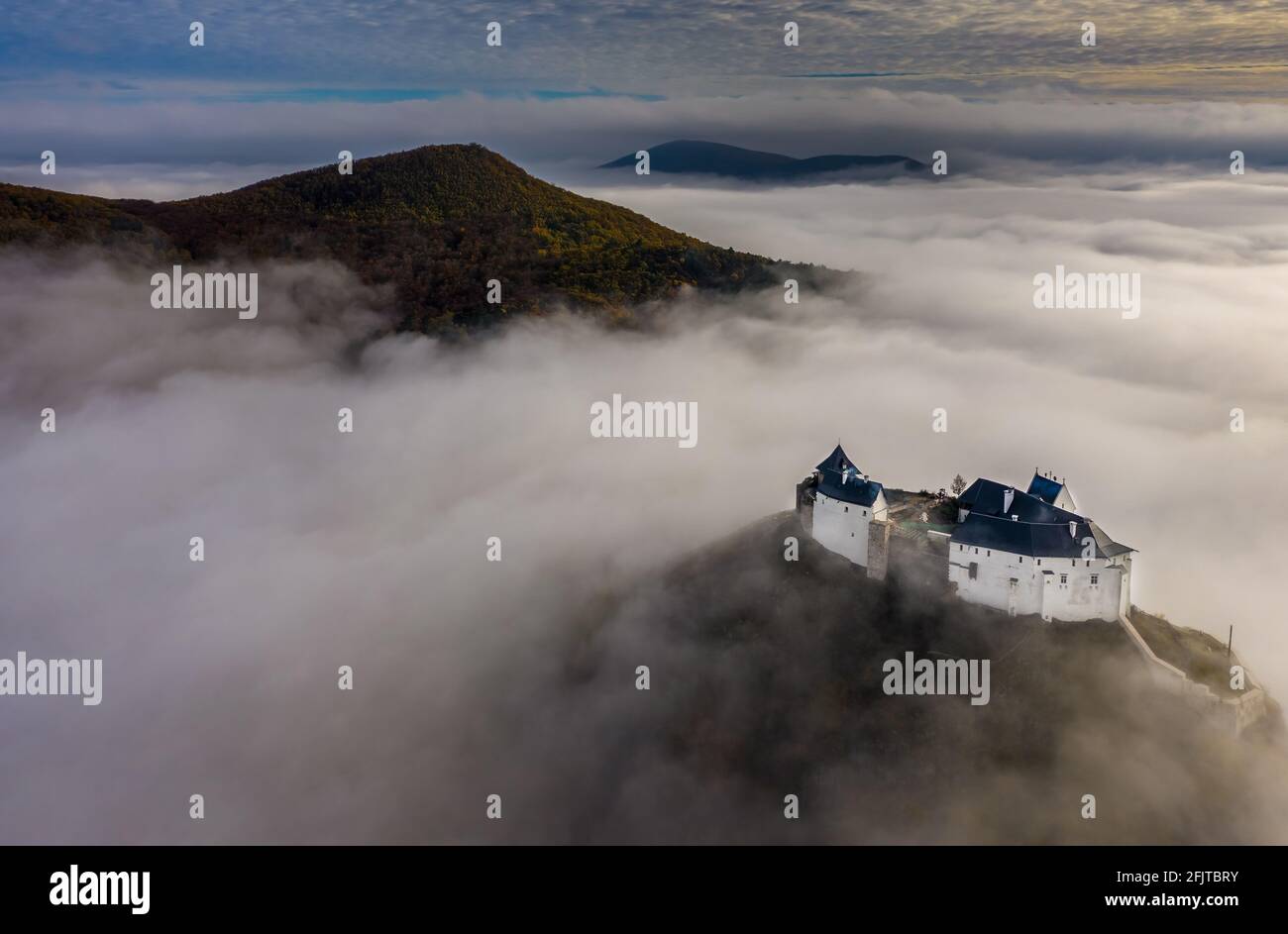 Fuzer, Hungary - Aerial panoramic view of the beautiful Castle of Fuzer standing out of the fog on an foggy autumn morning with Zemplen Mountains and Stock Photo