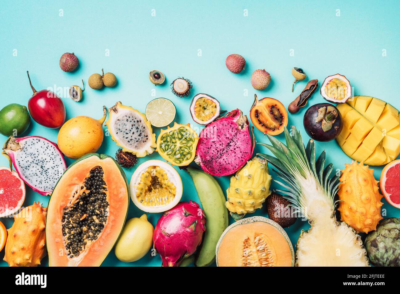 Tropical fruits concept. Exotic fruits - pineapple, papaya, mango, annona, banana, pitahaya, kiwano, african horned melon, tamarillo fruit, granadilla Stock Photo