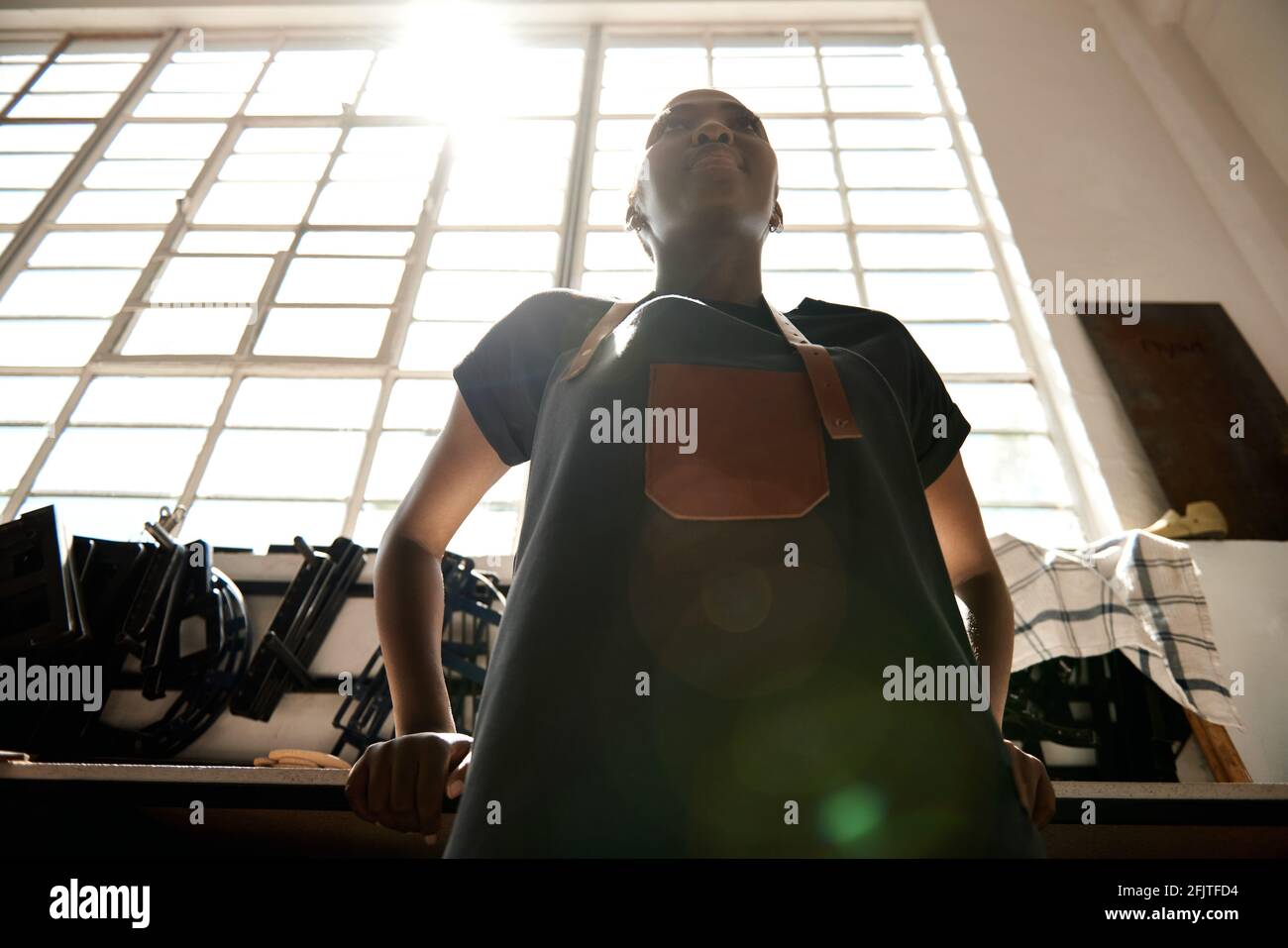 Young African female leather worker standing in her workshop Stock Photo