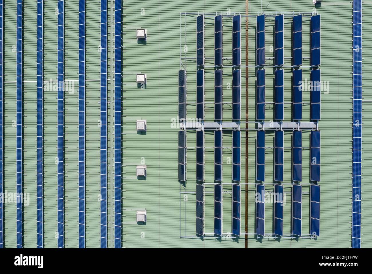 Solar panels and hot water heaters intalled on the building roof, aerial drone top down view Stock Photo