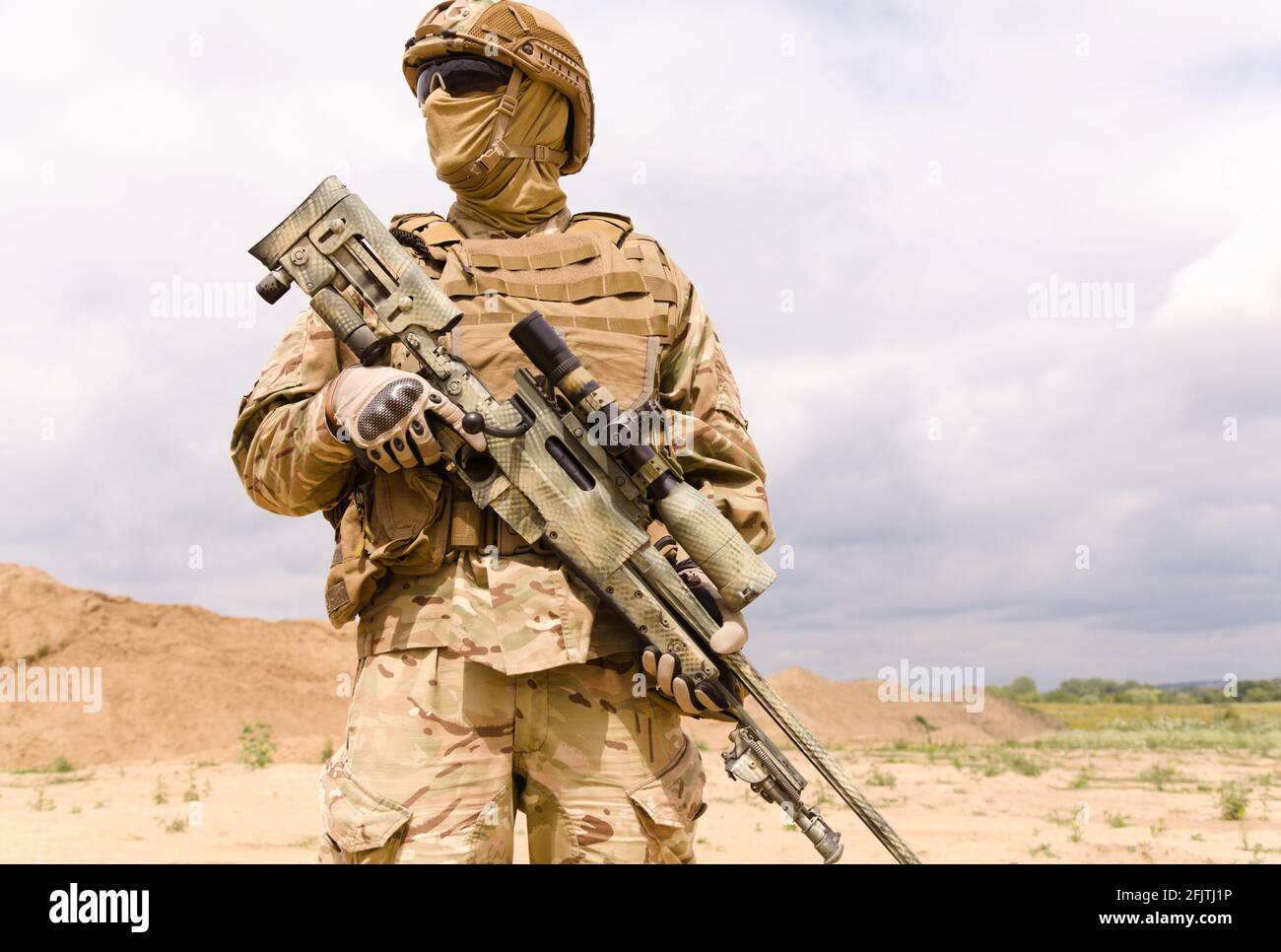 Portrait of armed special forces soldier with sniper rifle standing ...