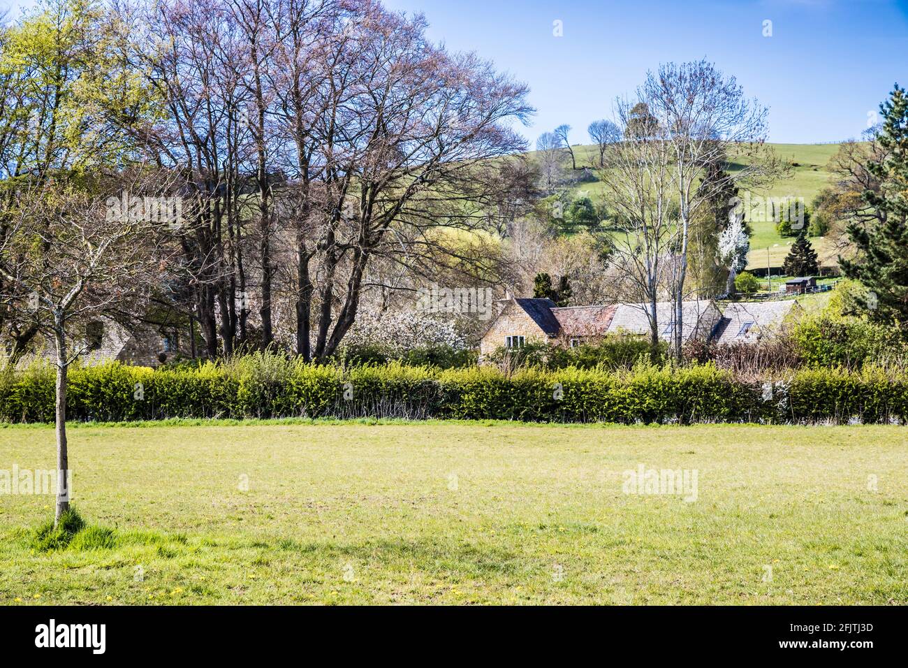 Attractive stone house set amidst the rolling Cotswold countryside. Stock Photo