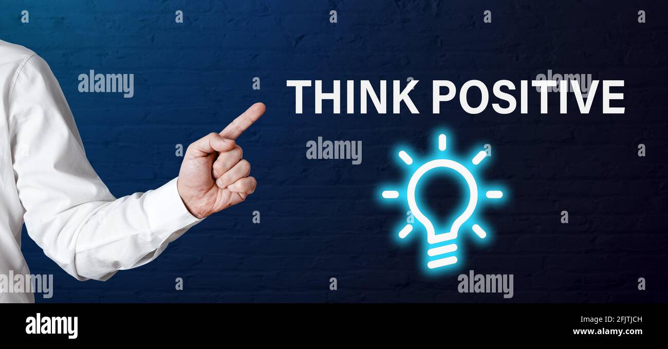 Businessman hand points to the word think positive with light bulb icon. Positive thinking or positivity for creativity in business concept. Stock Photo