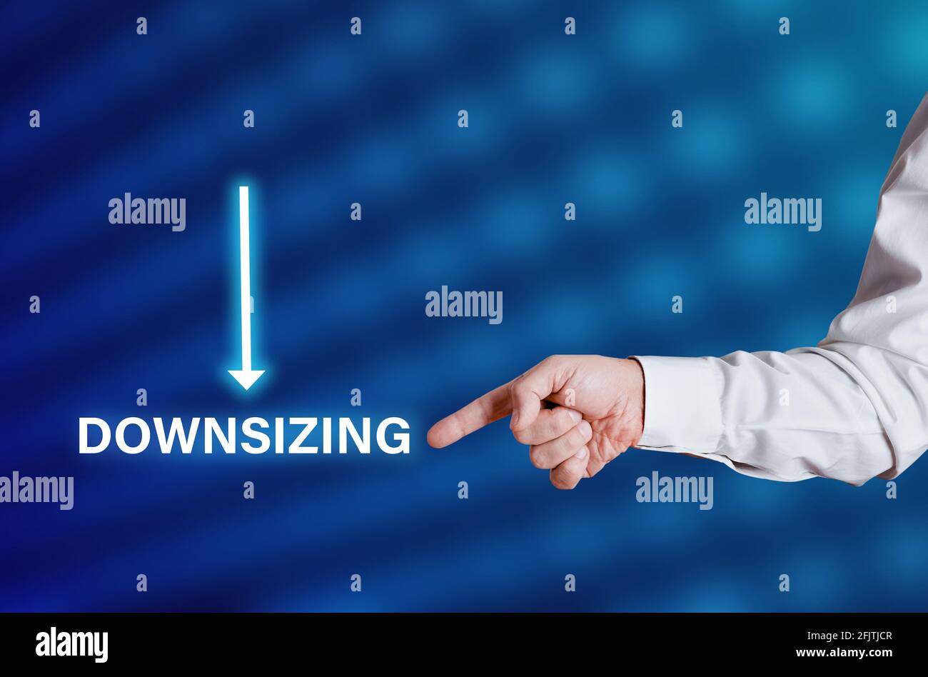 Businessman hand points to the word downsizing with downwards arrow icon. Corporate downsizing business concept. Stock Photo