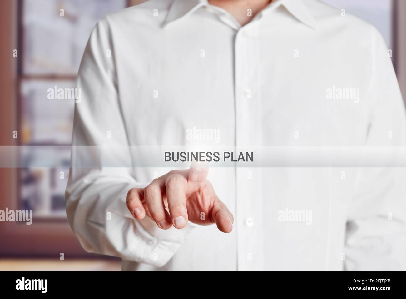 Male hand presses business plan button on a virtual touch screen. Stock Photo