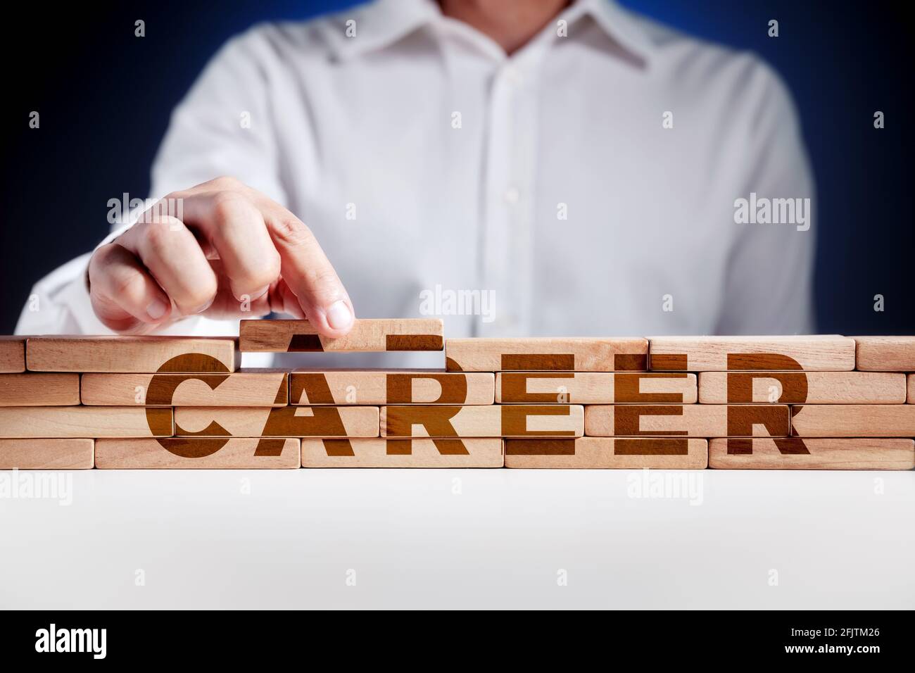 Businessman builds a structure of wooden blocks with the word career
