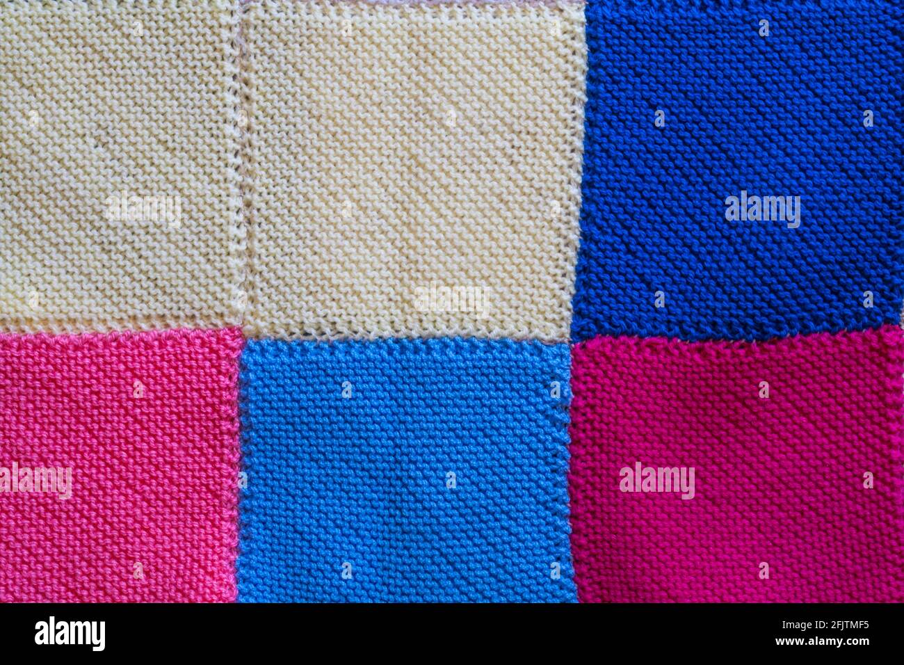 knitted squares sewn together to make a blanket, close up detail of