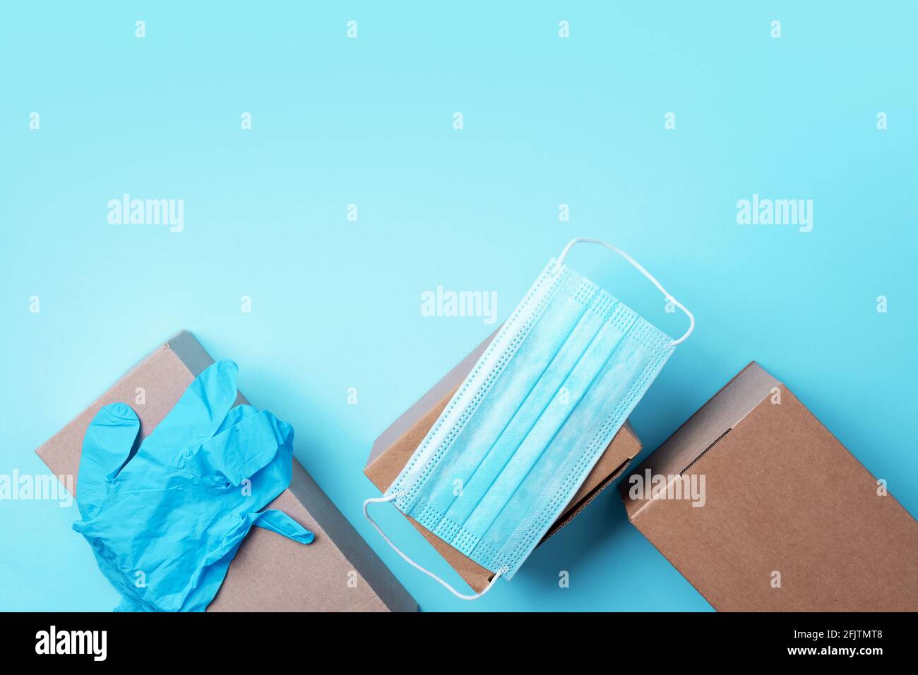 Craft paper cups, food box, gloves, bags, mask on blue background. Top view. Banner, copy space. Safe delivery, take away only concept. Food delivery Stock Photo