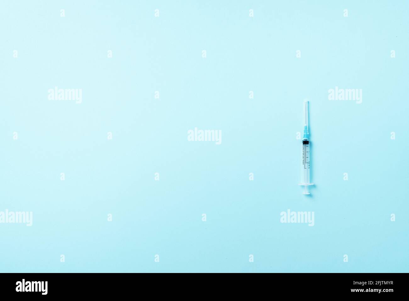 Syringe and needle on blue background. Injections and vaccination concept. Health protection equipment during quarantine Coronavirus pandemic Stock Photo