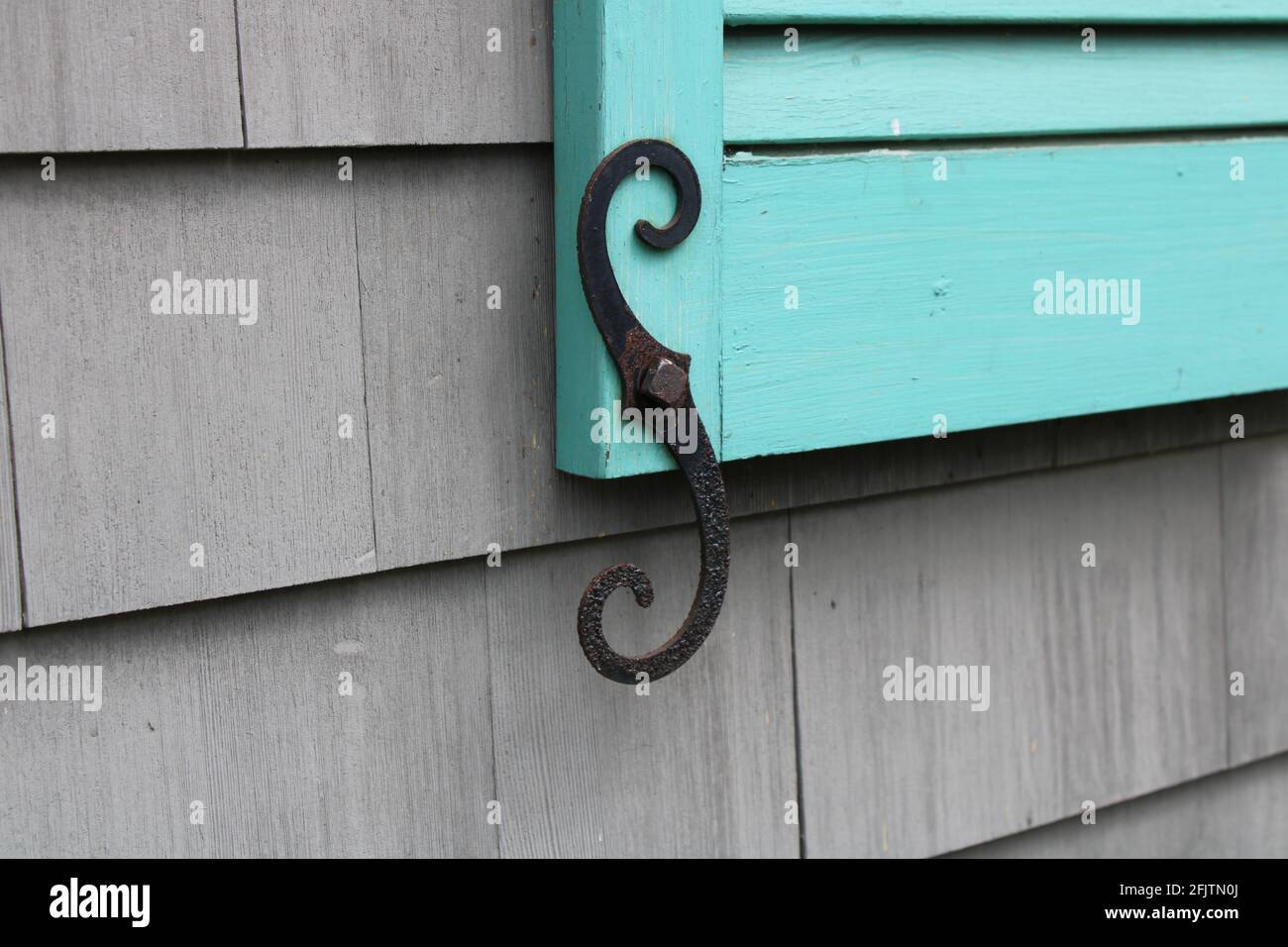 A Cast Iron Shutter Sash on A Turquoise Shutter Stock Photo