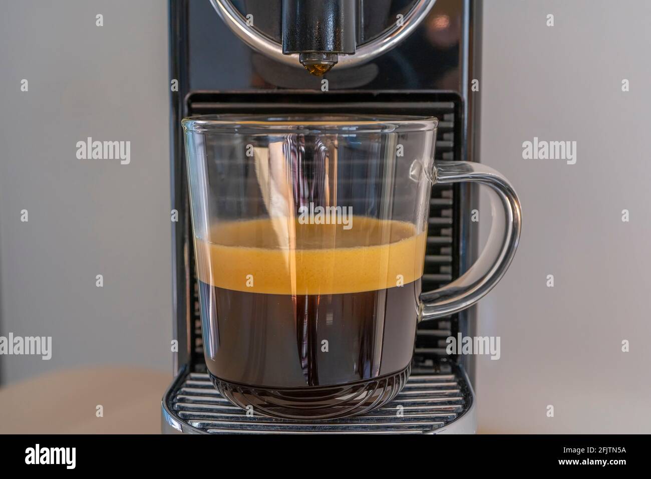 Making strong coffee with espresso machine at home. Front view. Stock Photo