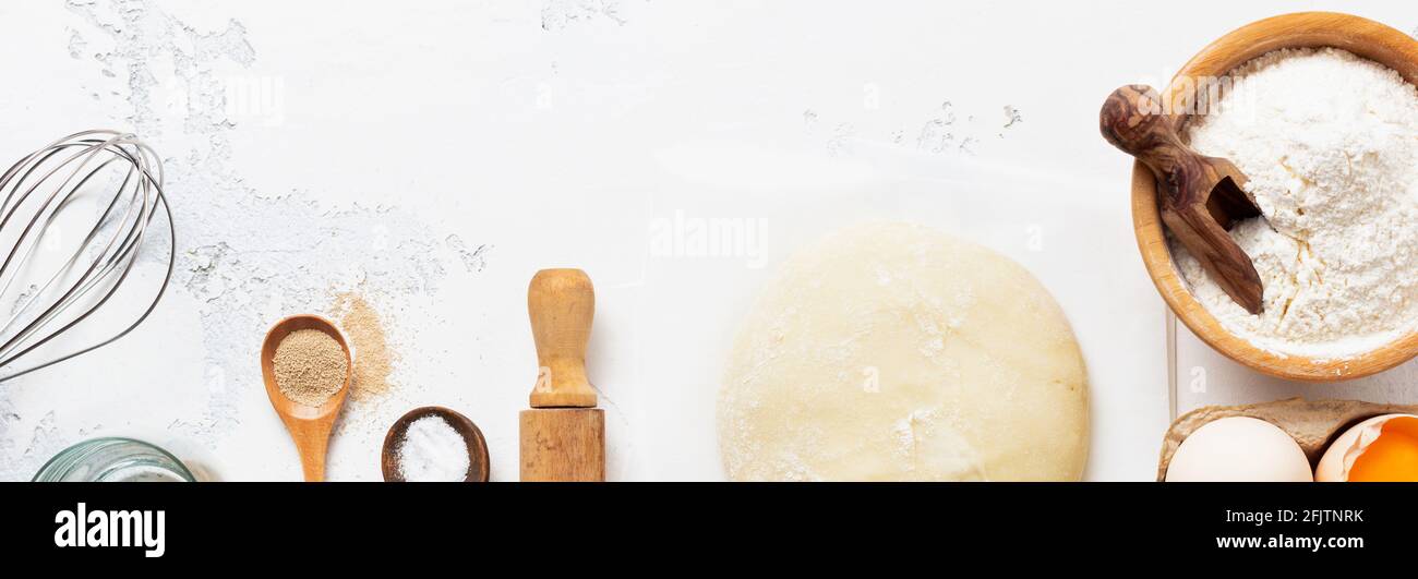 Baking background with dough and ingredients for the preparation of pasta or pancakes, eggs