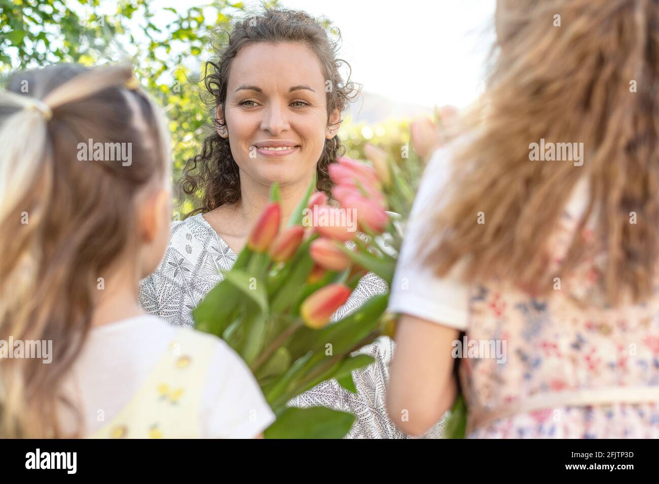 https://c8.alamy.com/comp/2FJTP3D/happy-mothers-day-little-cute-girls-holding-flowers-as-a-gift-for-her-mother-summer-garden-background-mothers-day-or-birthday-concept-2FJTP3D.jpg