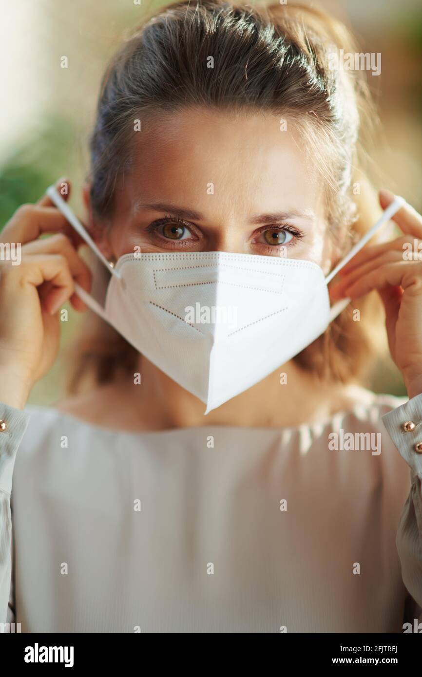 covid-19 pandemic. stylish woman in grey blouse wearing ffp2 mask. Stock Photo