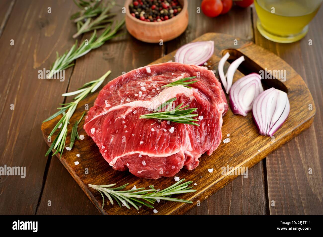 Raw beef steak on cutting board, close up view Stock Photo