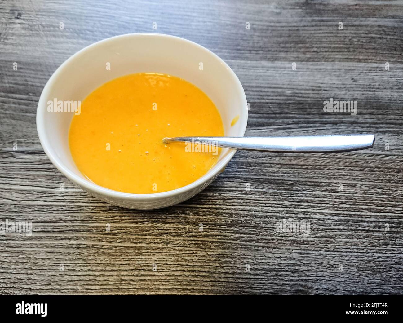 Beautiful colored cream pumpkin soup in plate, close up Stock Photo