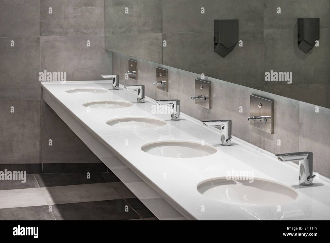 White sinks by the mirror in the public toilet Stock Photo Alamy