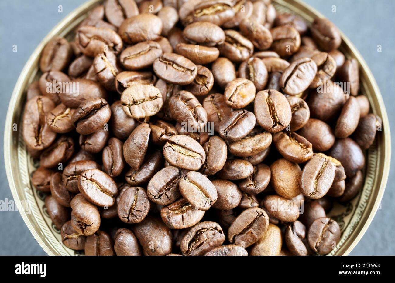 Roasted coffee beans in a bowl, selective focus. Stock Photo
