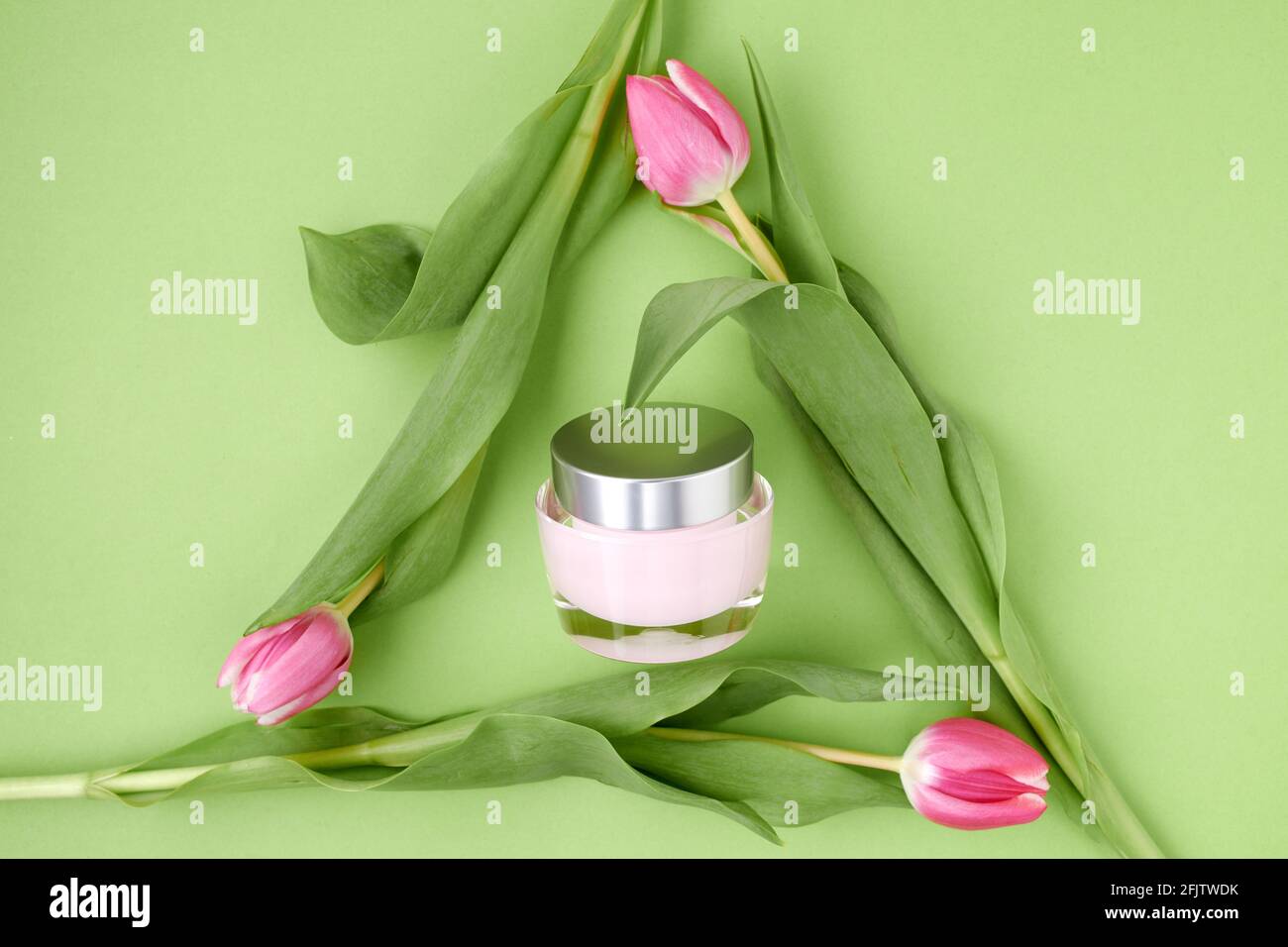 spring flat lay with tulips in recycle symbol and facial creme isolated ...