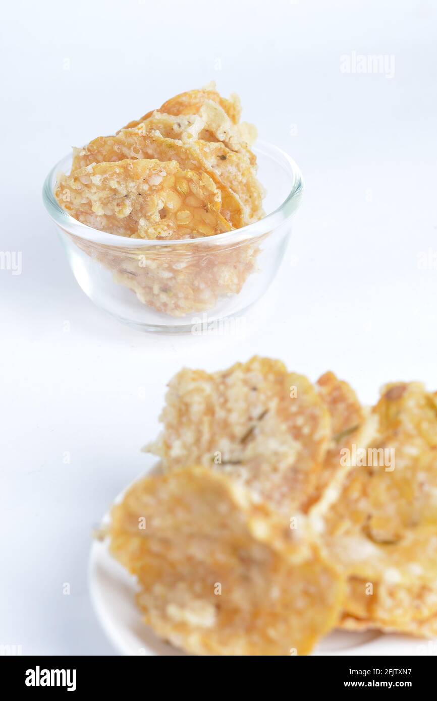 Keripik tempe , tempeh crackers in a plate. Indonesian traditional snack. White background Stock