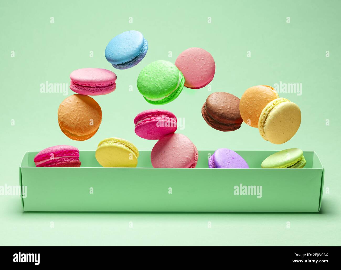 Colorful sweet macarons or macaroons, flavored cookies floating in the ...
