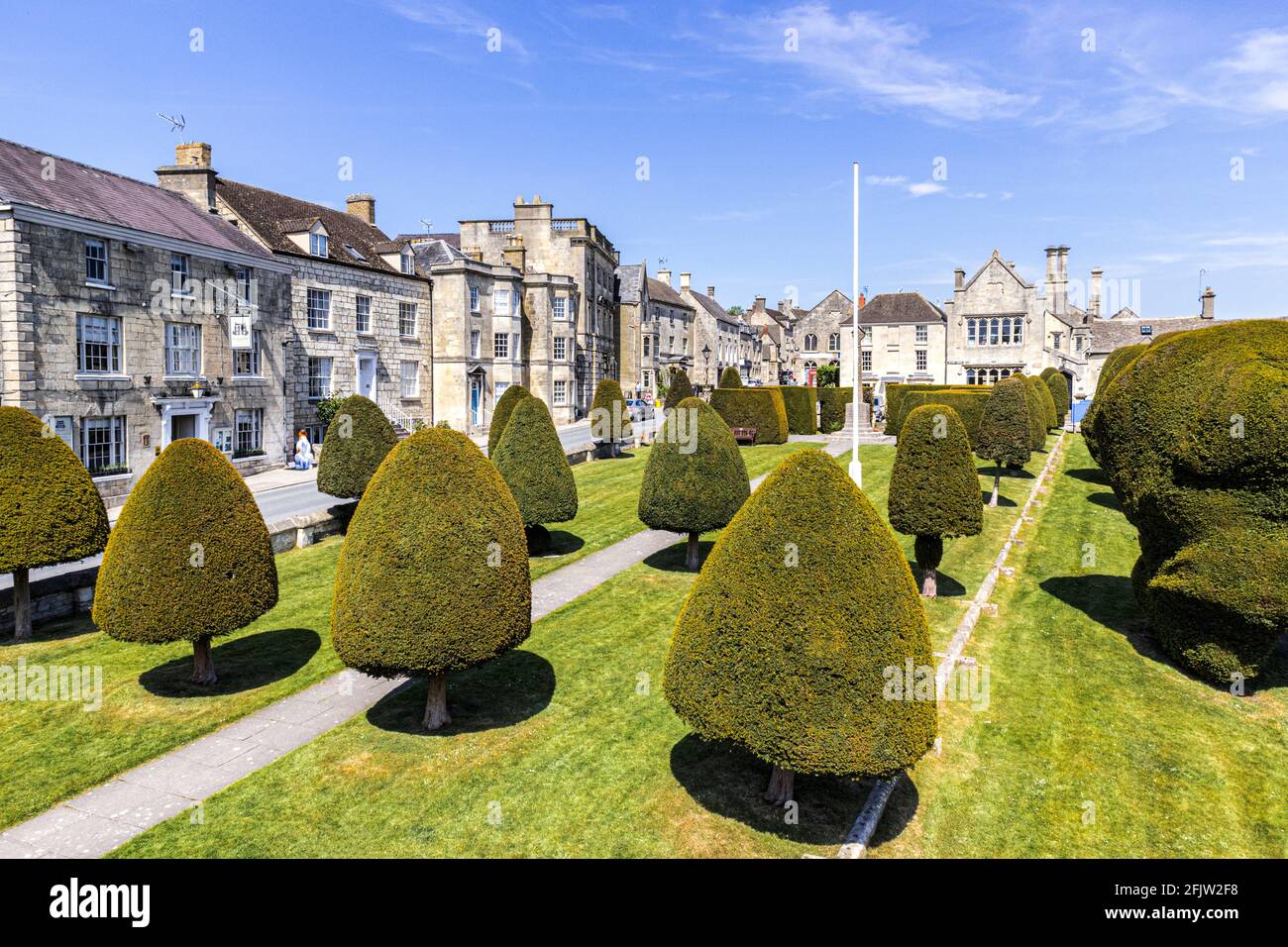 St Marys churchyard with some of its 99 yew trees in the Cotswold village of Painswick, Gloucestershire UK Stock Photo