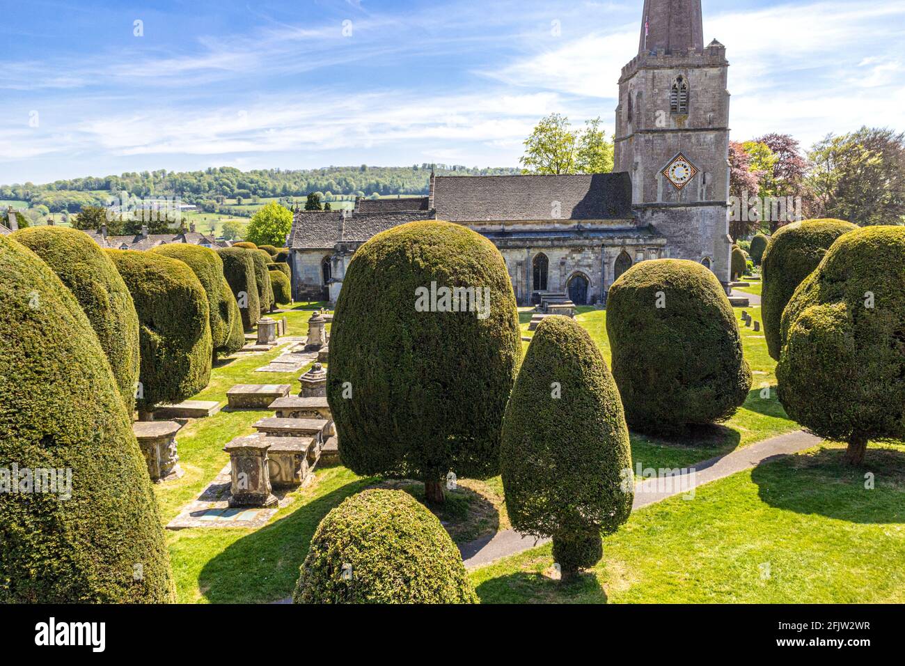 St Marys church with some of its 99 yew trees in the Cotswold village of Painswick, Gloucestershire UK Stock Photo