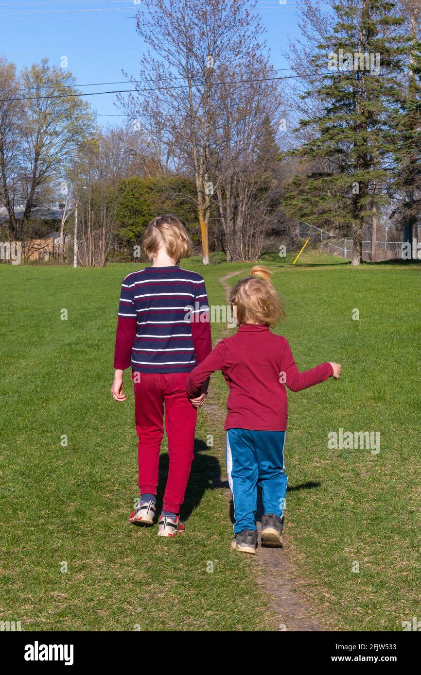 Two children hold hands hi-res stock photography and images - Alamy
