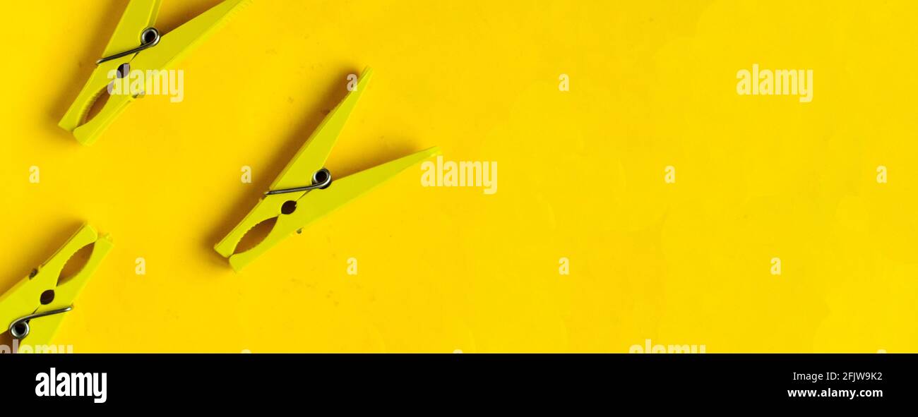 Top view, yellow clothespins on a yellow background, copyspace Stock Photo