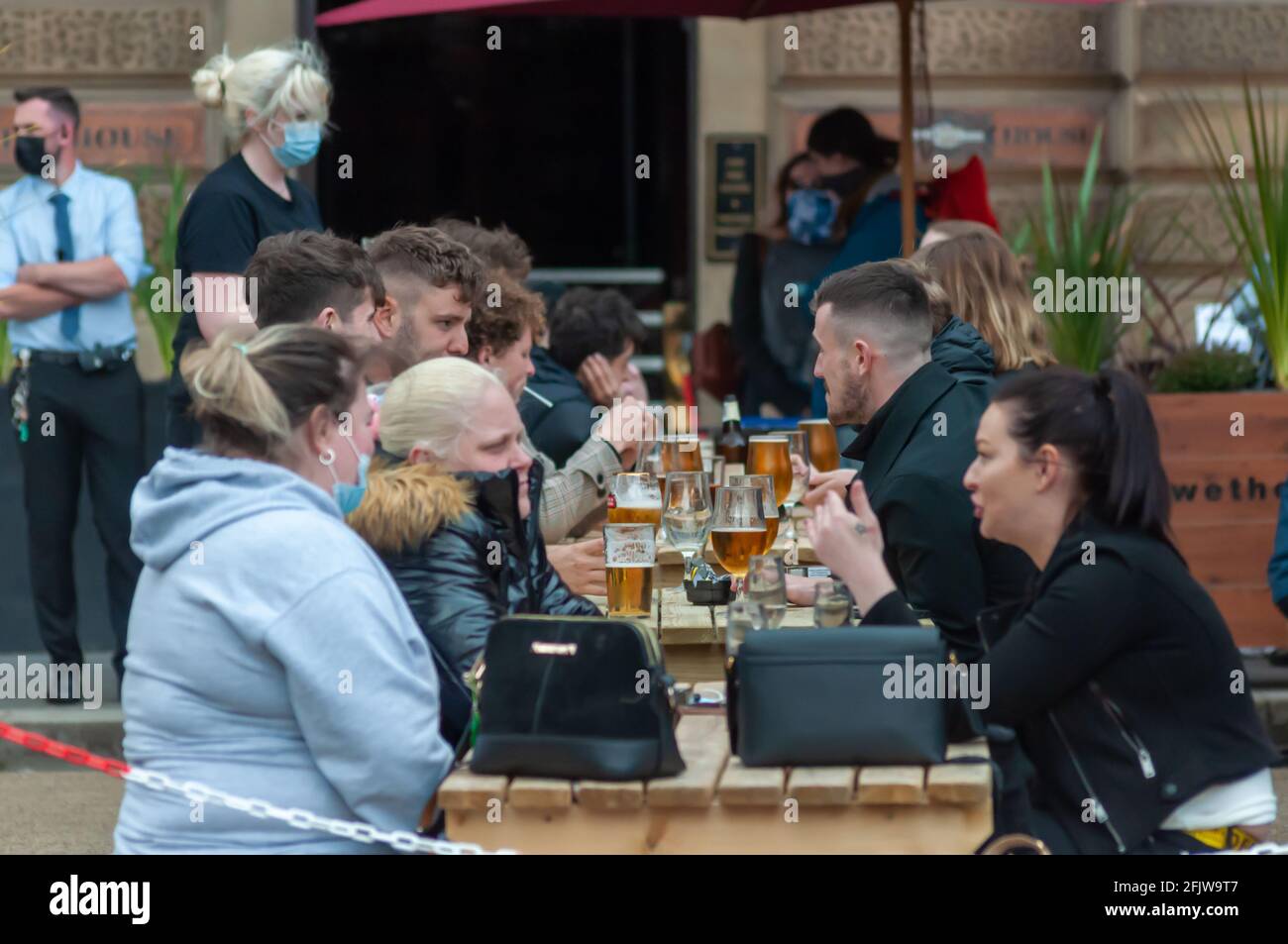 Glasgow, Scotland, UK. 26th April, 2021. People enjoying a drink outside in George Square. The lifting of coronavirus restrictions allows cafes, pubs, restaurants and non essential shops to open across Scotland. Credit: Skully/Alamy Live News Stock Photo