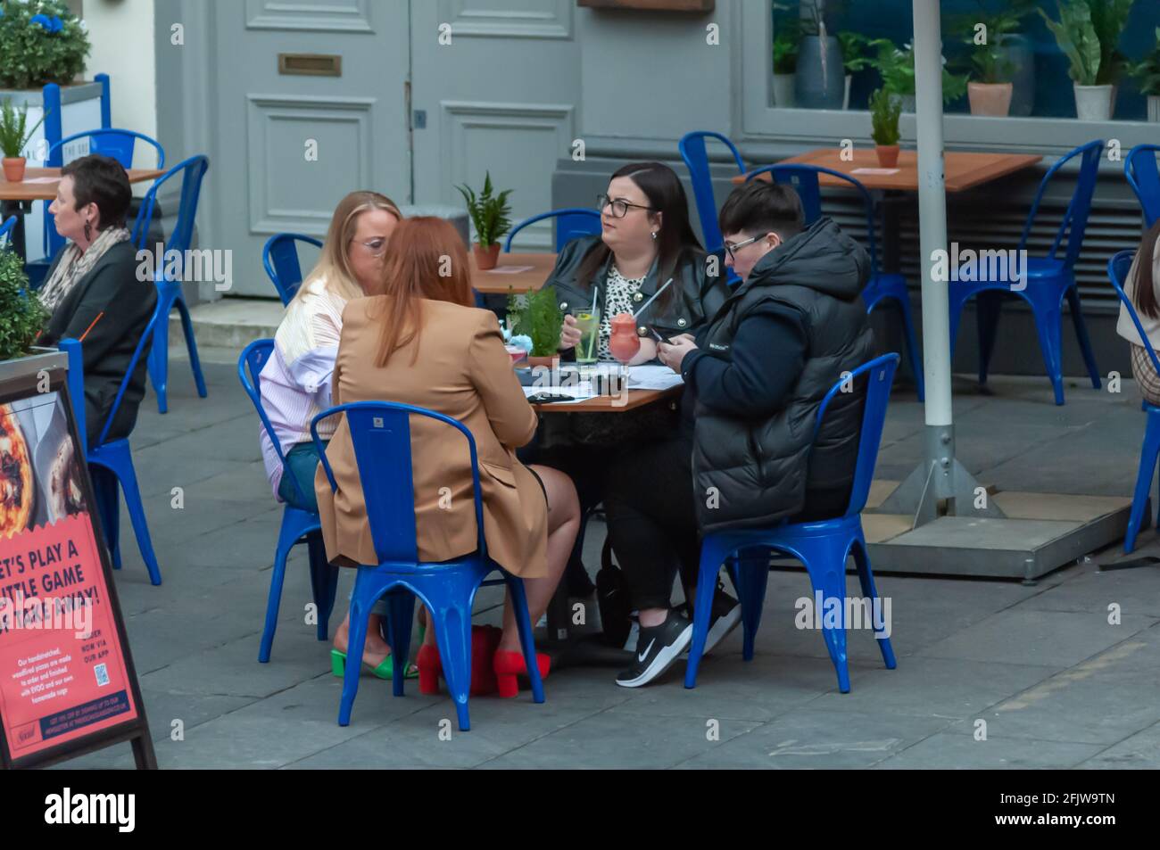 Glasgow, Scotland, UK. 26th April, 2021. People enjoying a drink outside. The lifting of coronavirus restrictions allows cafes, pubs, restaurants and non essential shops to open across Scotland. Credit: Skully/Alamy Live News Stock Photo