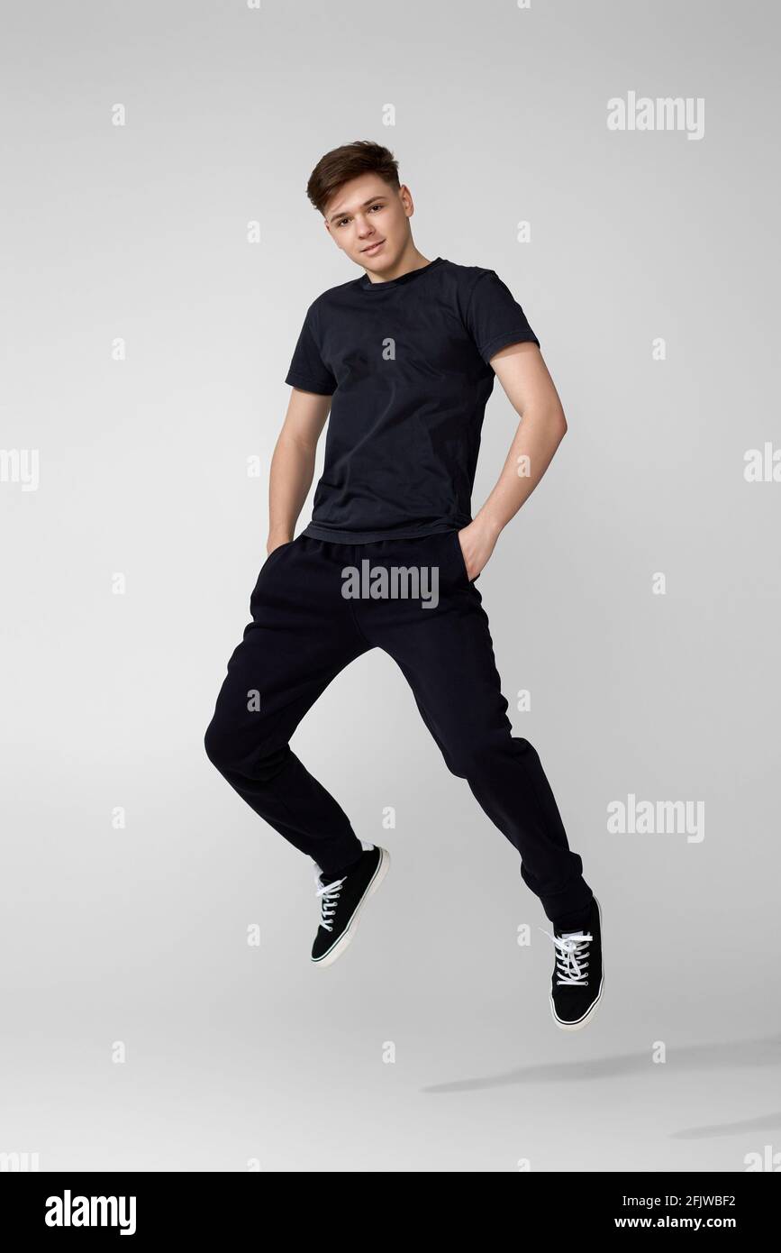 Handsome young man in black t-shirt jumping. Stock Photo