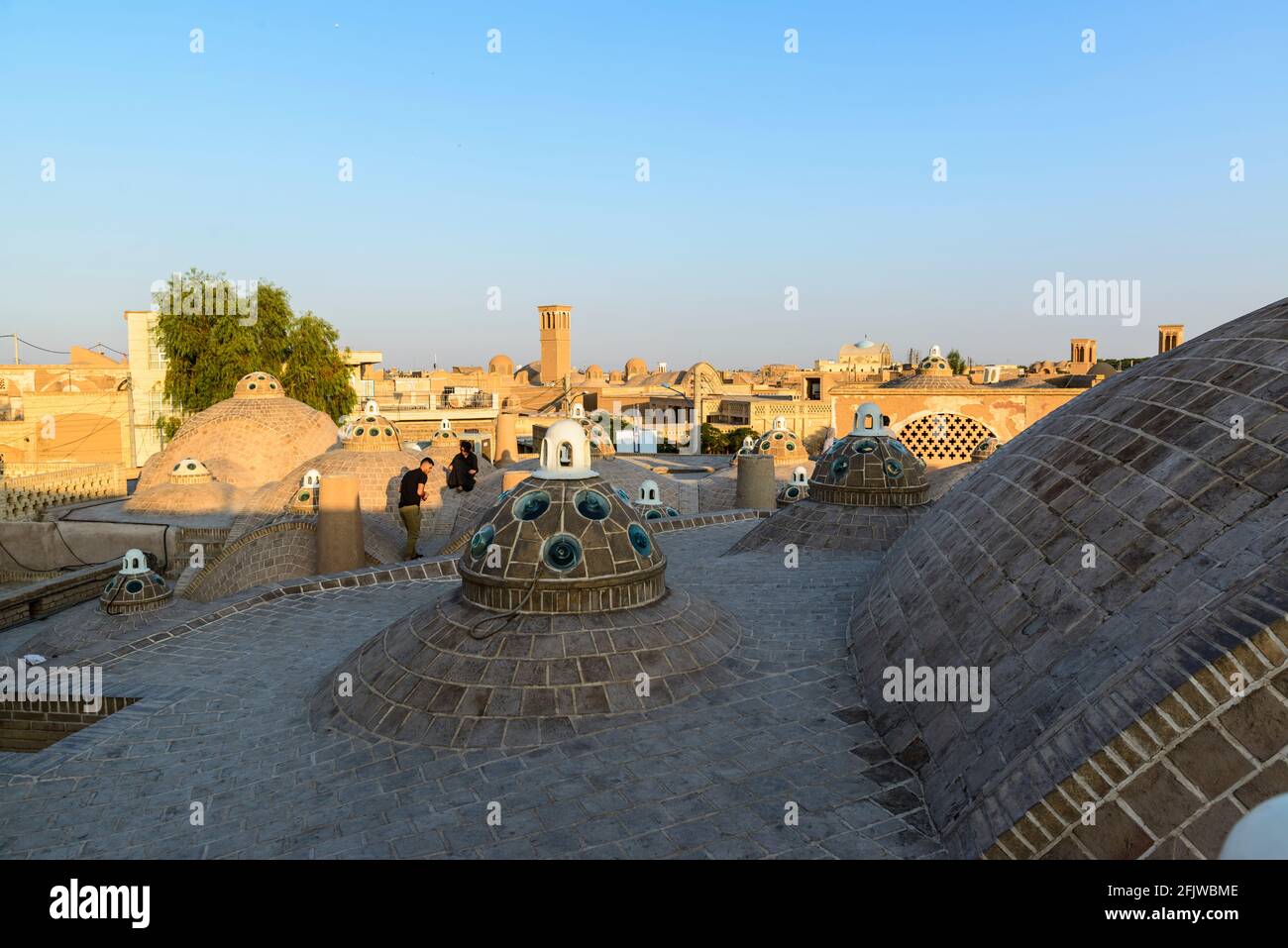 Two persons on the roof of the Sultan Amir Ahmad ( or Qasemi ) bathhouse with multiple domes . Kashan, Iran. Stock Photo