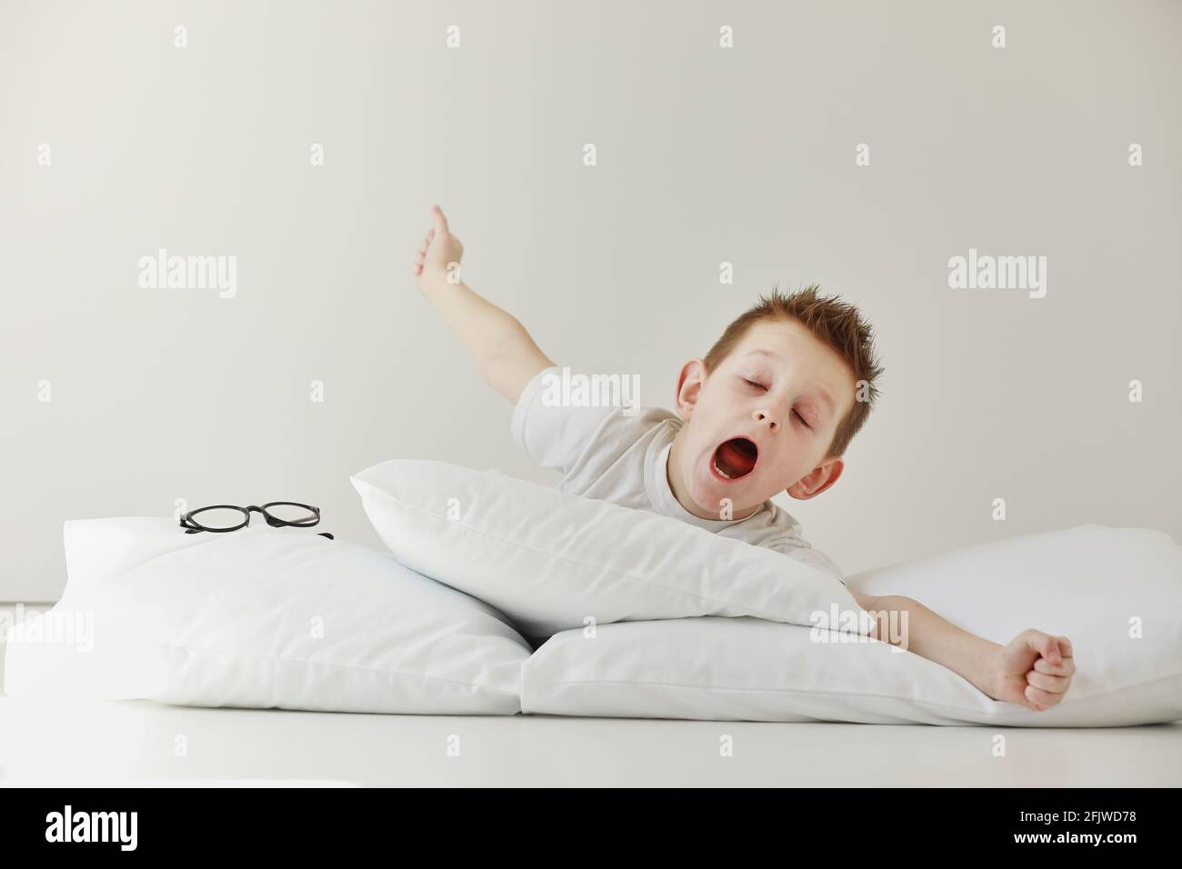 child boy wakes up and stretching on his comfortable bed in morning, Health  care and good morning world concept. Stretches and yawns Stock Photo - Alamy, image size:1300x956