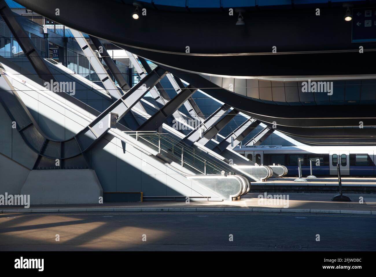 Modern architecture of Reading Train Station showing the new escalators and a train standing at one of the new platforms - Reading, Berkshire, England Stock Photo