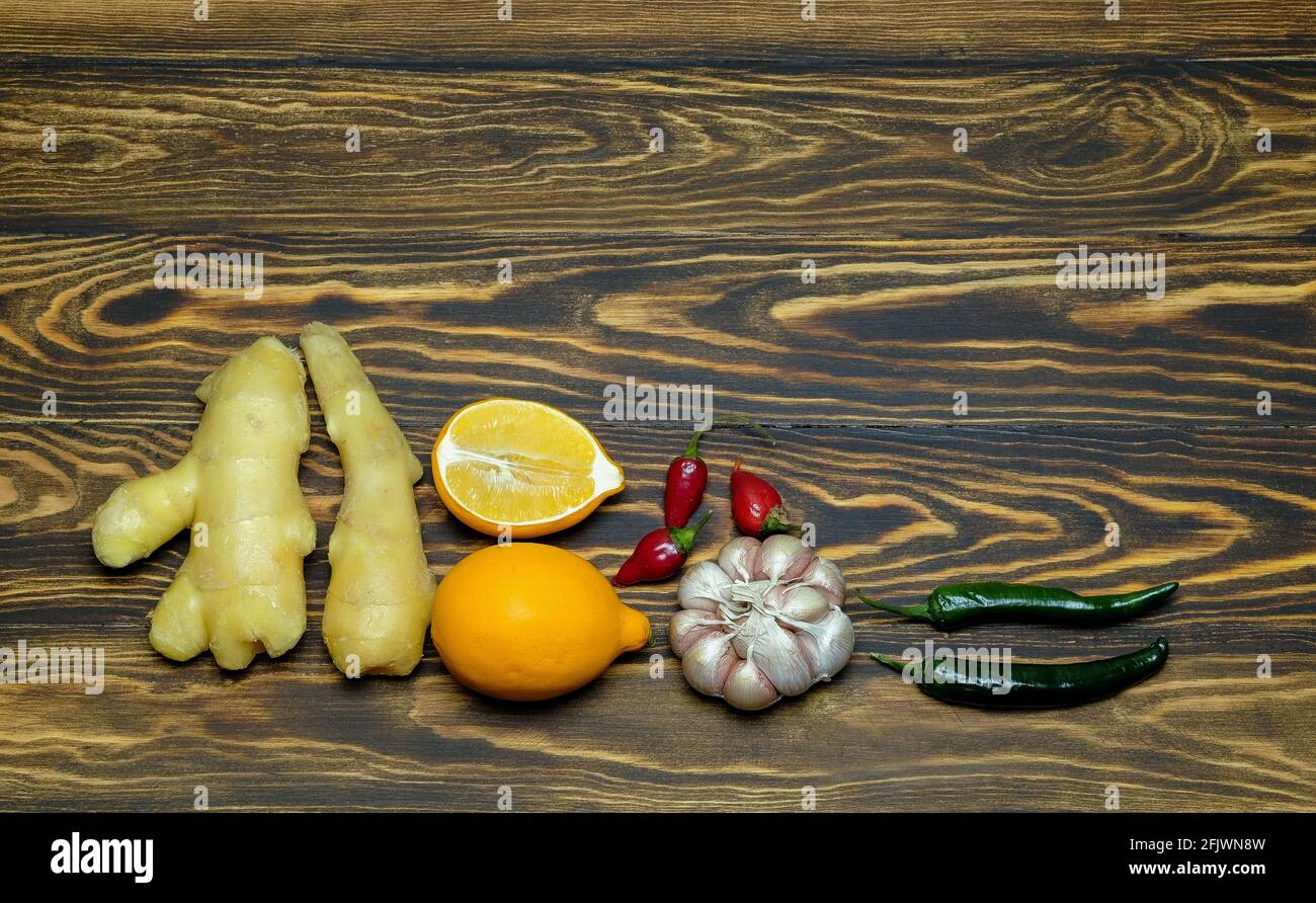 ginger root with lemons, garlic, chili pepper on a wooden background Stock Photo