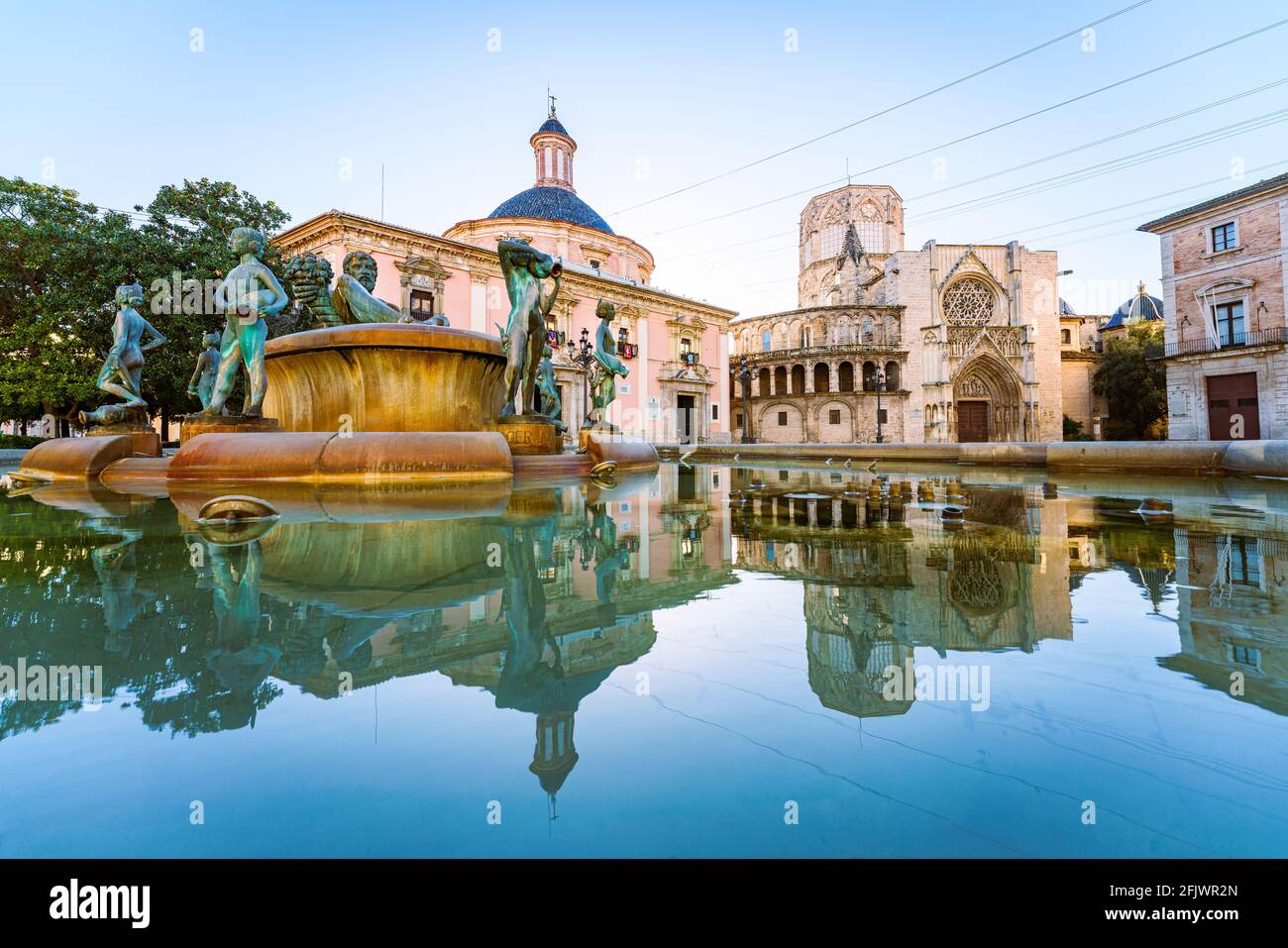 Valencia city Spain. The Gothic Cathedral reflected on the fountain of Plaza de La Virgen Stock Photo