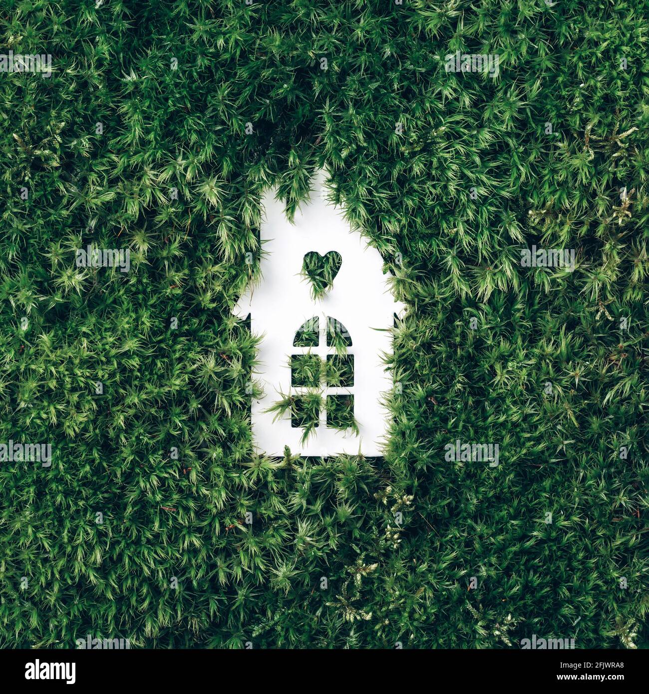Eco house concept. Top view. White house model on green grass, forest moss background. Top view. Copy space. Eco friendly house. Zero waste, organic Stock Photo