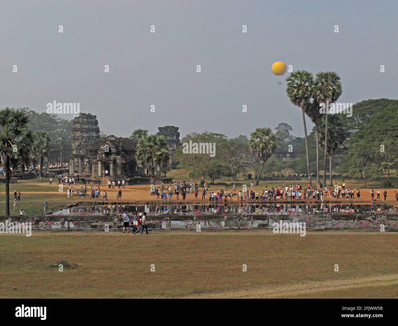 crowds of tourists at the temple in the early morning with hot air baloon Angkor Wat, Seim Reap, Cambodia         January Stock Photo